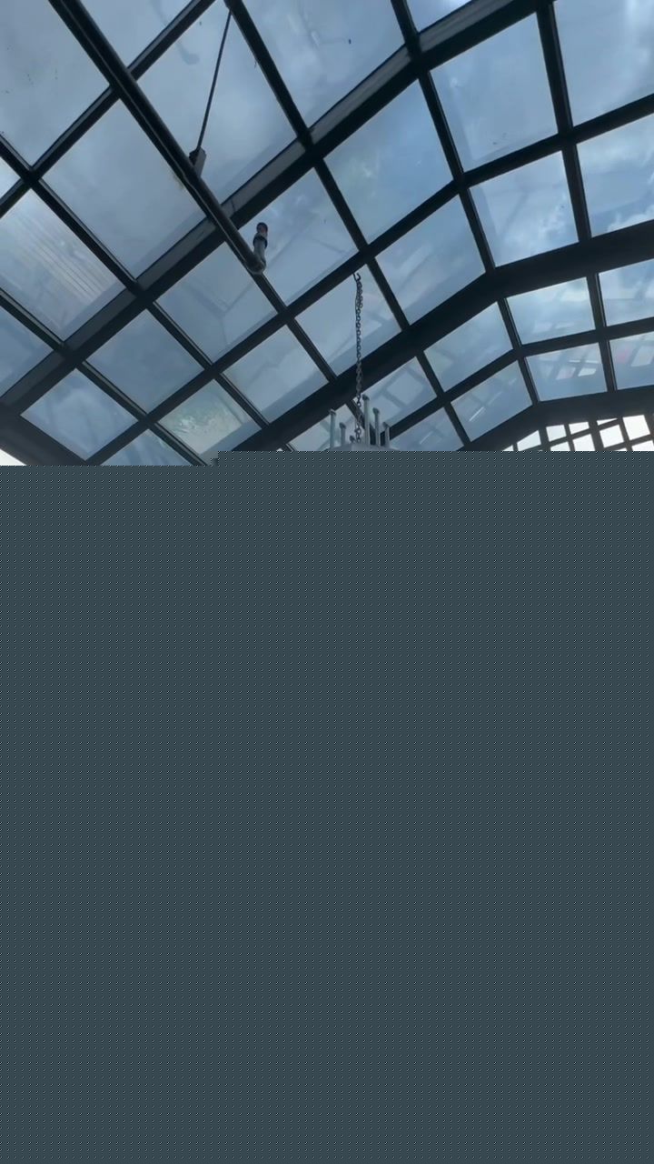 Seltsam glass ceiling structure with hanging light and city view